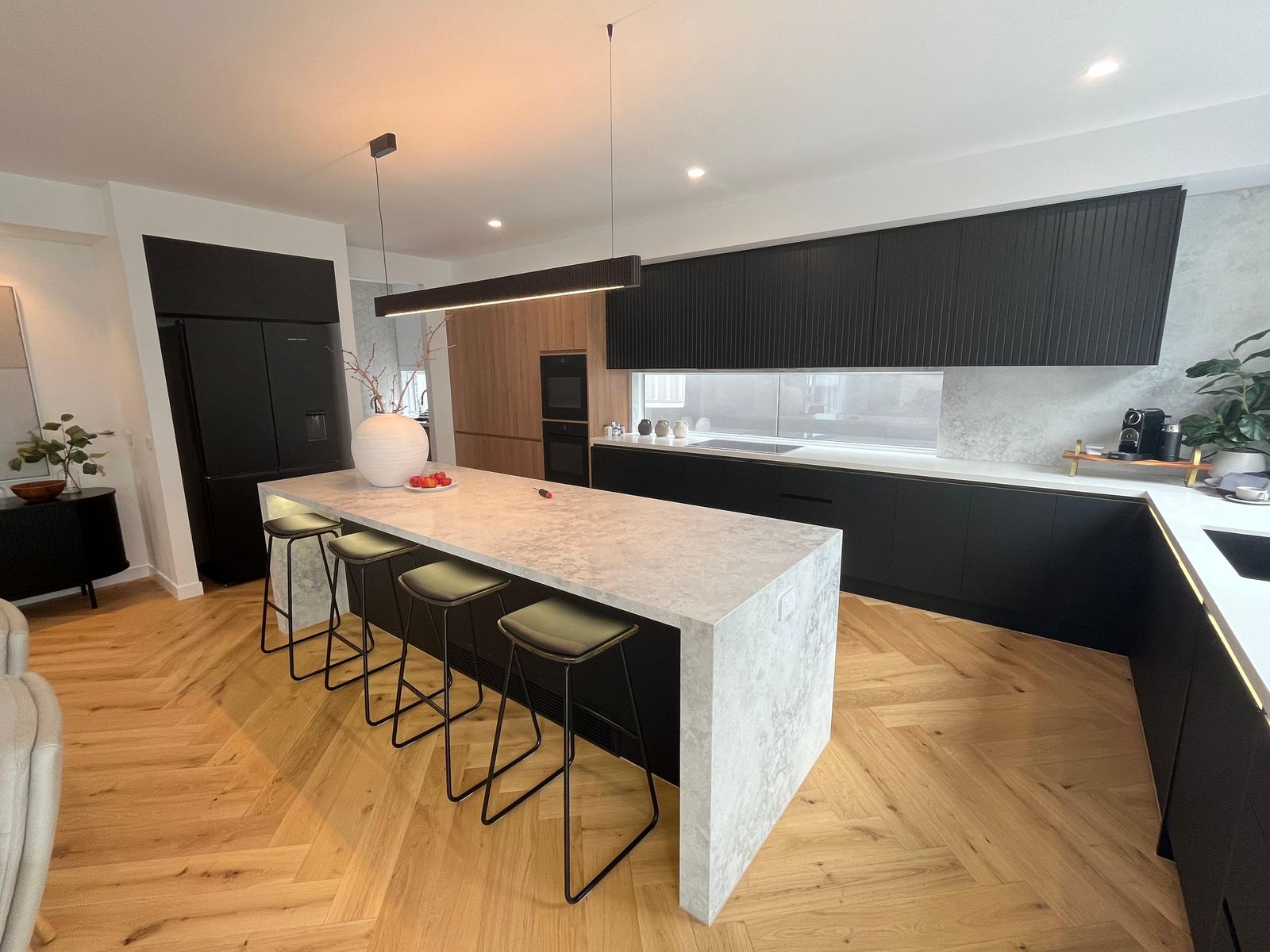 Modern matte black kitchen with waterfall marble island, manufactured by Oktay Cabinets