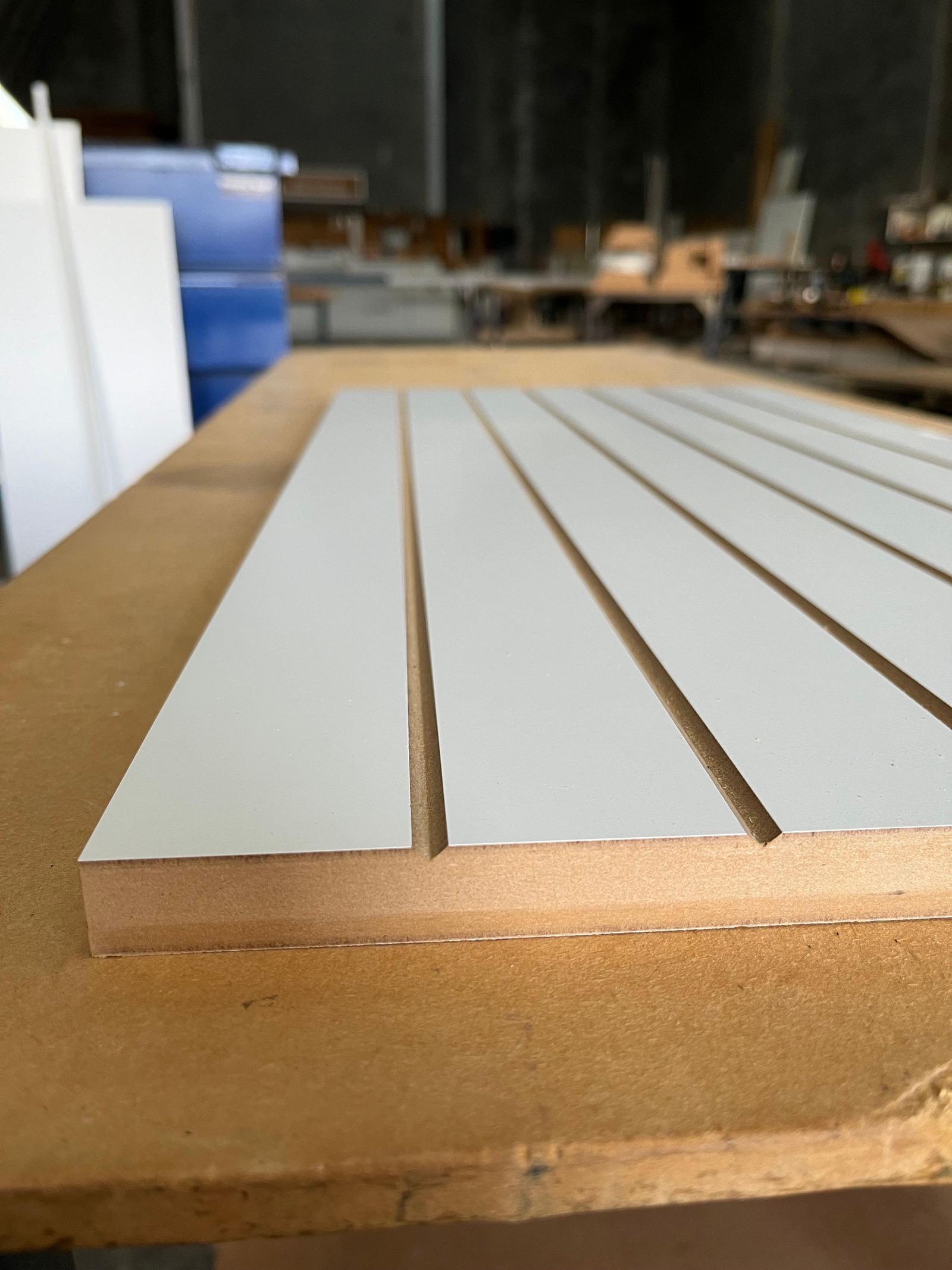 White slat panel sample showing precise CNC grooving