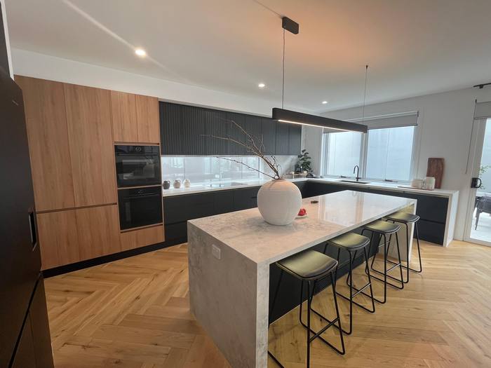Timber-veneer kitchen with island and pendant lighting