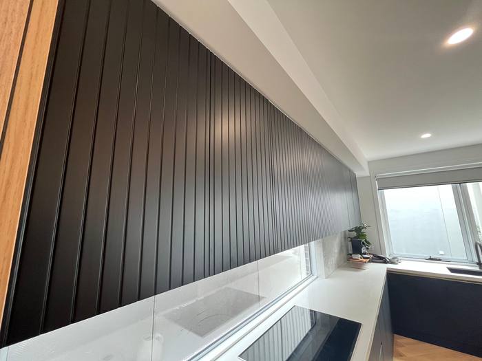 Black kitchen with waterfall island, alternate view