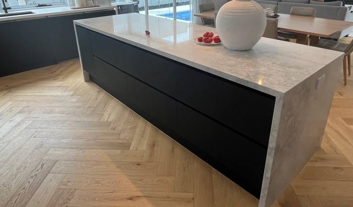 Marble waterfall island with black cabinetry